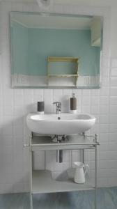 a bathroom with a sink and a mirror at Residenza Se son Rose in Schignano