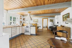a kitchen with white cabinets and a wooden ceiling at 5617-Svaneke-Per-Sorens-Gade-2 in Svaneke