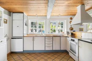a kitchen with white cabinets and a wooden ceiling at 5617-Svaneke-Per-Sorens-Gade-2 in Svaneke +12 photos