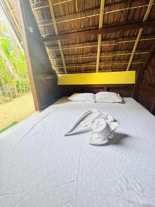 a bed with a flower on top of it at Destiny Rainbow Beach Resort in Siquijor
