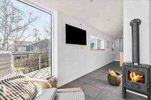 a living room with a fireplace and a tv at 6663-Allinge-Stien-4 in Allinge