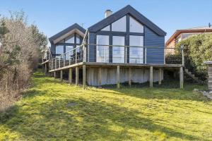 a blue house with a large deck on a lawn at 6663-Allinge-Stien-4 in Allinge