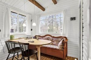 a room with a table and a bed with windows at 4743-Ronne-Stampen-Vej-4-Hus-4 in Rønne