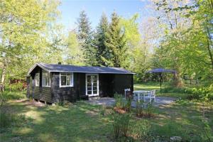 a small cabin in the woods with an umbrella at 4743-Ronne-Stampen-Vej-4-Hus-4 in Rønne