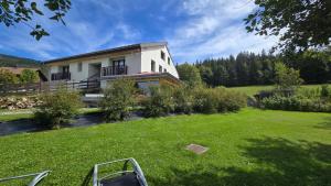 una casa en un campo con un patio en MV Vacances, en Les Rousses