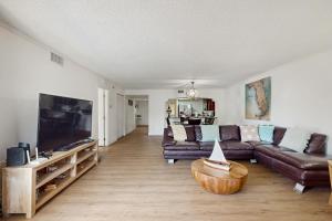 a living room with a couch and a flat screen tv at Beach Cottage 1104 in Clearwater Beach