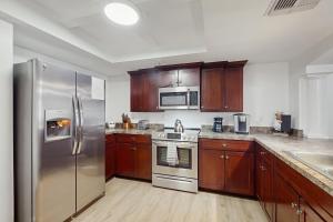 a kitchen with stainless steel appliances and wooden cabinets at Beach Cottage 1104 in Clearwater Beach