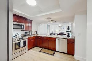 a kitchen with wooden cabinets and white appliances at Beach Cottage 1104 in Clearwater Beach +16 photos