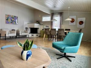 sala de estar con silla azul y mesa en Spacious house - Free parking - King beds, en Tromsø