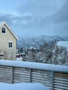 una casa y una valla cubiertas de nieve en Spacious house - Free parking - King beds, en Tromsø
