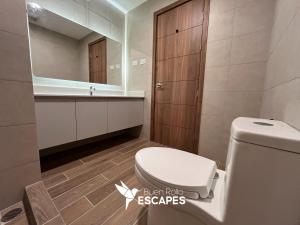 a bathroom with a toilet and a sink and a mirror at Luxury High-Floor 3 Bedroom Apartment FREE Pool & Gym in Guatemala