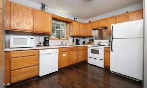 a kitchen with a white refrigerator and wooden cabinets at Hidden Love in Gatlinburg +16 photos