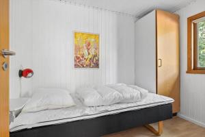 a bed in a room with a painting on the wall at 4706-Aakirkeby-Sondre-Landevej-58 in Åkirkeby