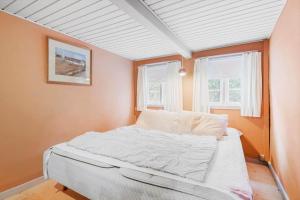 Bett in einem Zimmer mit 2 Fenstern in der Unterkunft 5568 Gudhjem - Melsted By 19 in Gudhjem