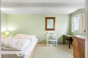 Schlafzimmer mit einem Bett, einem Spiegel und einem Schreibtisch in der Unterkunft 5568 Gudhjem - Melsted By 19 in Gudhjem + 14 Fotos