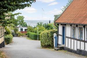 eine leere Straße neben einem Haus mit Blick auf das Meer in der Unterkunft 5568 Gudhjem - Melsted By 19 in Gudhjem