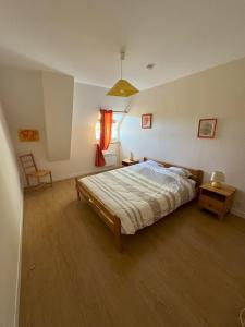a bedroom with a bed and a table and a chair at Domaine Saint Jean in Saint-Côme-du-Mont
