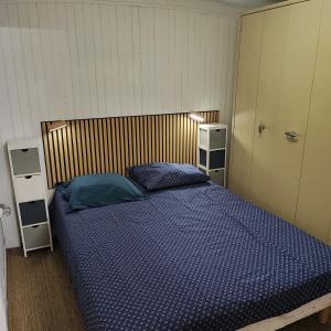 een slaapkamer met een bed met een blauw dekbed bij Chalet atypique in Anglès