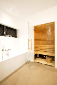a bathroom with a shower and a glass door at Haus Berta Exklusives Architektenhaus Fehmarn, strandnah in Fehmarn +65 photos