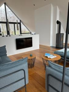 a living room with a tv and a couch and a table at Haus Berta Exklusives Architektenhaus Fehmarn, strandnah in Fehmarn