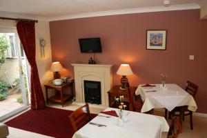 a dining room with two tables and a fireplace at Churston Way Lodge Guest House in Brixham