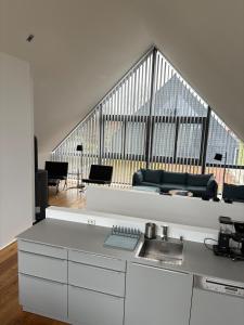 a kitchen with a couch and a living room at Haus Berta Exklusives Architektenhaus Fehmarn, strandnah in Fehmarn