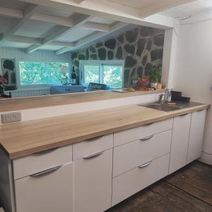 een keuken met witte kasten en een houten aanrechtblad bij Chalet atypique in Anglès