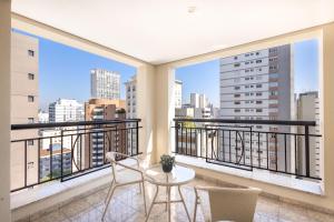 a balcony with two chairs and a table at George V Casa Branca in Sao Paulo