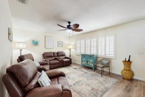 a living room with two couches and a ceiling fan at Avocado Cottage in Seminole