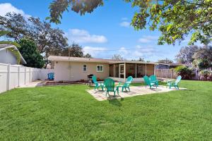 a yard with chairs and a table and a house at Avocado Cottage in Seminole