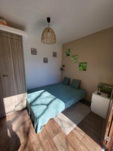 una camera da letto con un letto con un copriletto blu di La Cabane a Saint-Michel-le-Cloucq