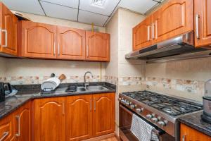 a kitchen with wooden cabinets and a stove top oven at Luxury Oceanfront Fully Furnished 2BR! in Ajman 