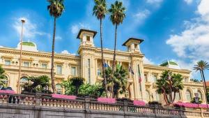 a large building with palm trees in front of it at Tiny studio, rustic style, historic center in Sanremo