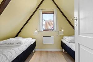 due letti in una stanza con finestra di 5554-Svaneke-Bakken-1 a Svaneke