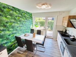 a kitchen with a table and chairs with a green leafy wall at Fewo am Tüllinghof in Lüdinghausen