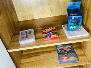 a wooden shelf with books and games on it at Fewo am Tüllinghof in Lüdinghausen