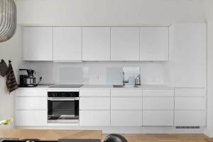 a white kitchen with white cabinets and an oven at 4797-Allinge-Havnevej-14-C-1-th in Allinge +11 photos