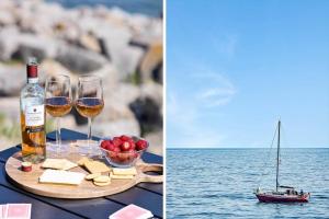 a table with two glasses of wine and a boat on the water at 4797-Allinge-Havnevej-14-C-1-th in Allinge