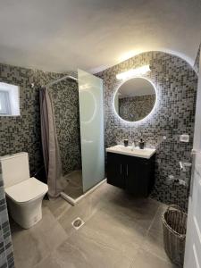 a bathroom with a toilet and a sink and a mirror at Aethera Apartments in Megalochori +6 photos