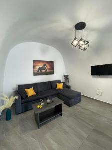 a living room with a blue couch and a table at Aethera Apartments in Megalokhori