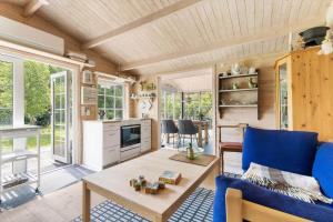 a tiny house with a blue couch and a table at 6832-Hasle-Toftegardsvej-20-C in Hasle