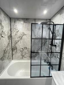 a bathroom with a shower and a bath tub at Spacious 4-Bedroom Family Home in Giffnock Glasgow in Pollokshaws