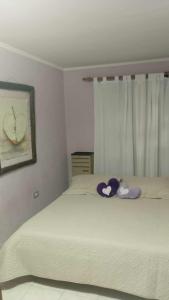 a bedroom with a bed with a stuffed animal on it at La casa de Angelita in Trelew +1 photo