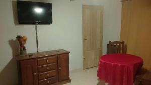 a room with a dresser and a tv on a wall at La casa de Angelita in Trelew