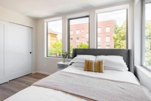 a bedroom with a large white bed with windows at Centro House 8A - New in Seattle