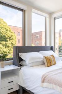 a bedroom with a bed with white sheets and a window at Centro House 8A - New in Seattle