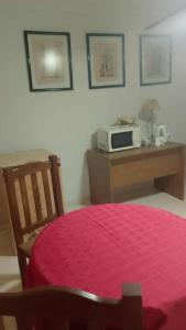 a bedroom with a bed and a microwave on a table at La casa de Angelita in Trelew