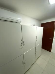 a row of white lockers in a room at Ohmvue Floripa in Florianópolis