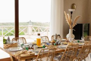 una mesa de madera con comida y sillas en Villa Cactuswell, en Essaouira