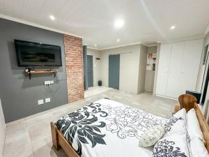 a bedroom with a bed and a tv on a wall at Blade Flatlet 2 in Silver Sands